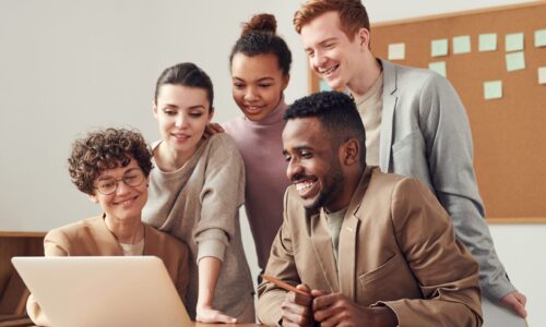 Equipe reunida em volta de um notebook